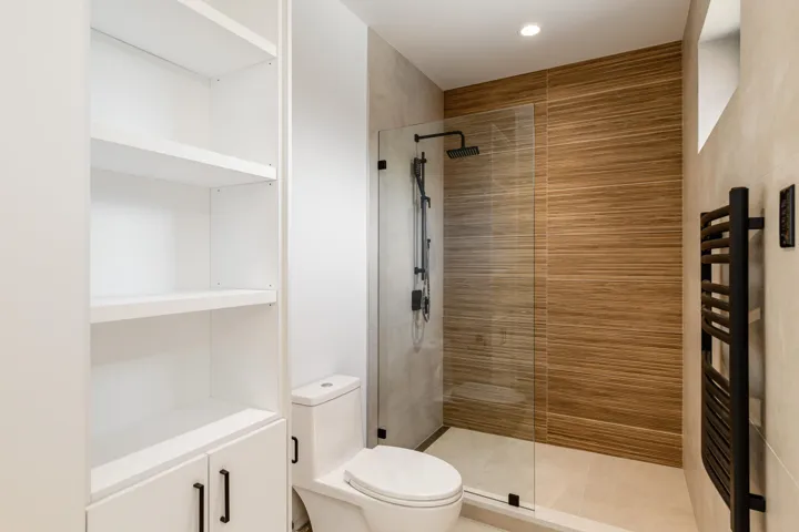 Full bath with a tile shower, radiator, recessed lighting, and tile patterned flooring
