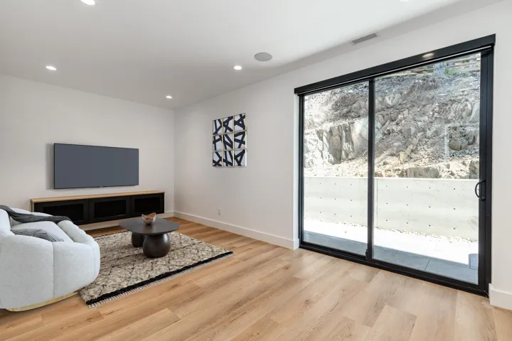 Living room with light wood-style flooring and recessed lighting