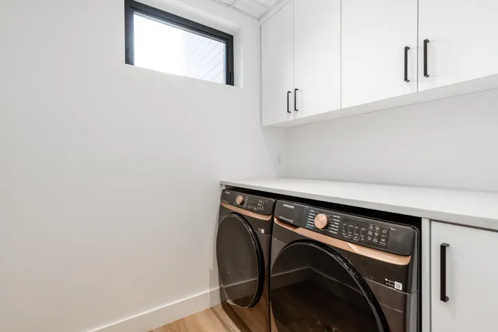 Laundry area with cabinet space, washing machine and clothes dryer, and light wood finished floors