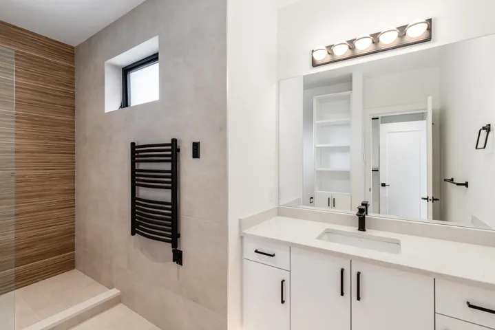 Full bathroom featuring radiator, vanity, a towel warming rack, and a tile shower