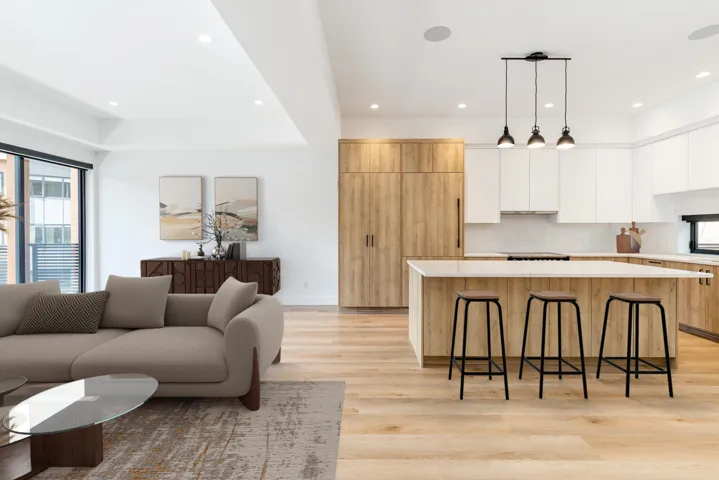 Kitchen with modern cabinets, a kitchen island, a kitchen bar, light countertops, and white cabinets