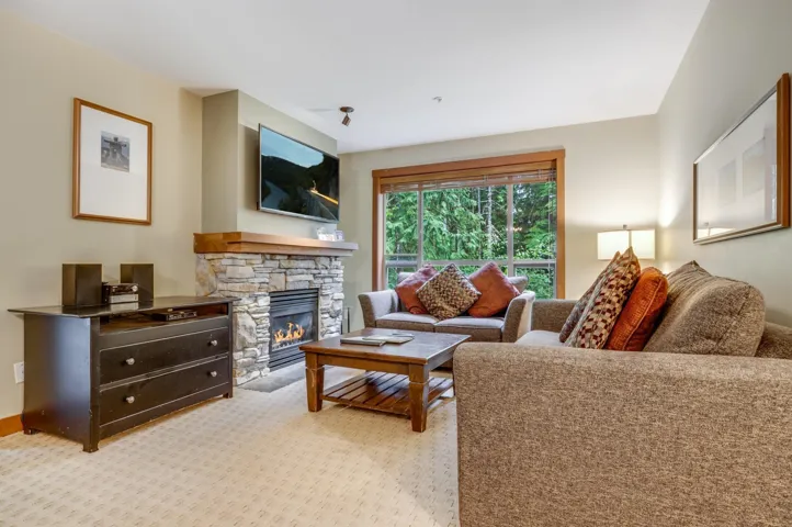 Living area featuring a stone fireplace and light colored carpet