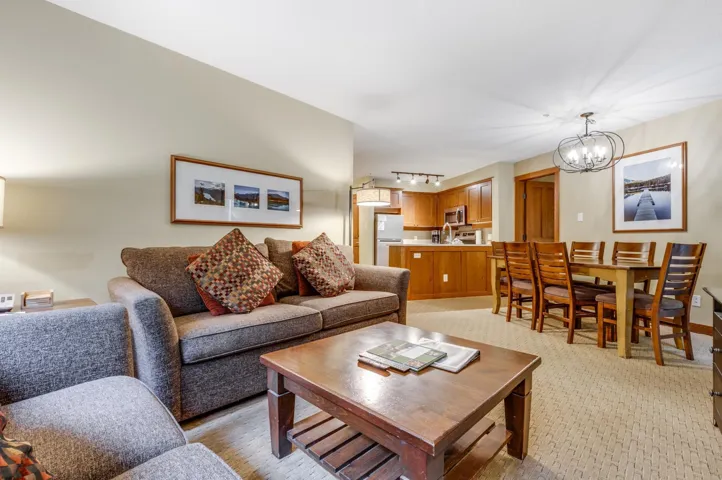 Living room featuring light carpet and a chandelier