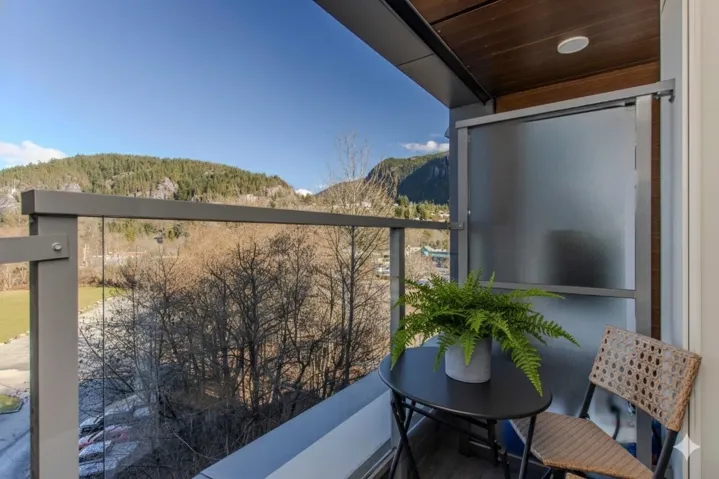 Private balcony featuring a glass railing and mountain backdrop