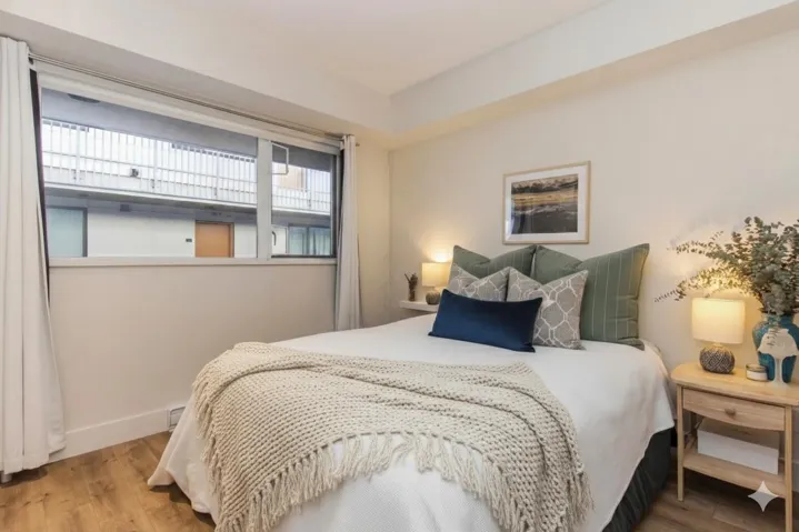 Bedroom featuring wood-finish flooring, a wide window, and light-toned wall paint
