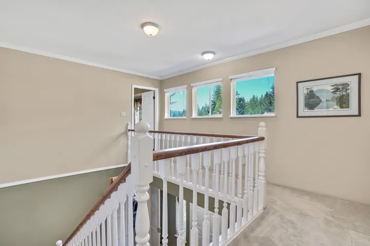 Corridor with an upstairs landing, crown molding, and carpet floors