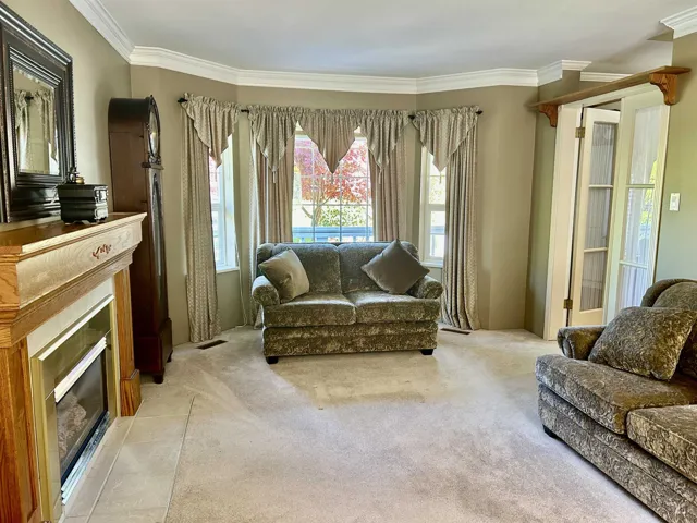 Living area featuring a gas fireplace, crown molding