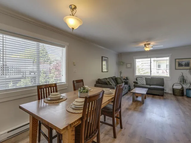 Dining room with a baseboard heating unit, ceiling fan, crown molding, and light wood-style flooring