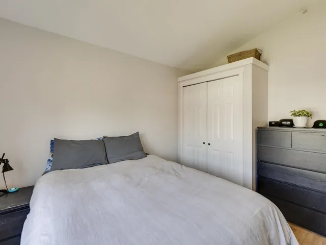 Bedroom featuring lofted ceiling, wood finished floors, and a closet