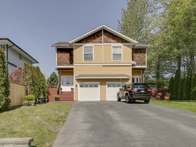 Craftsman house featuring an attached garage, aphalt driveway, fence, and a front lawn