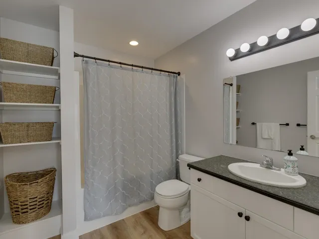 Full bath featuring toilet, recessed lighting, shower / tub combo, wood finished floors, and vanity