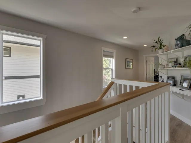 Hall featuring recessed lighting, dark wood finished floors, and an upstairs landing