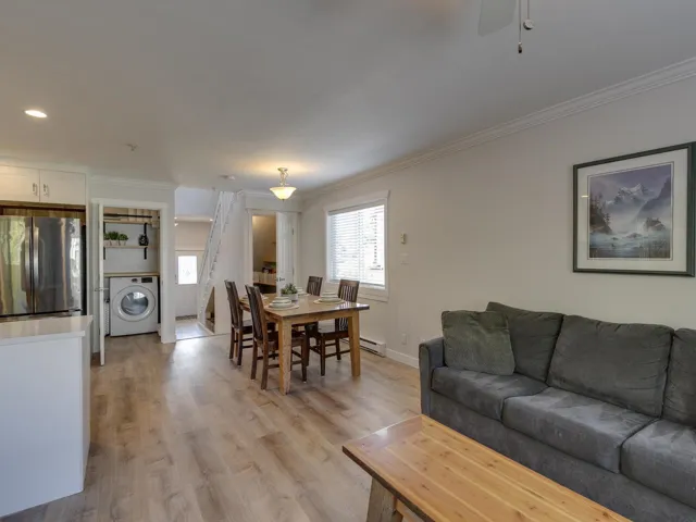 Living area featuring washer / dryer, a healthy amount of sunlight, and crown molding
