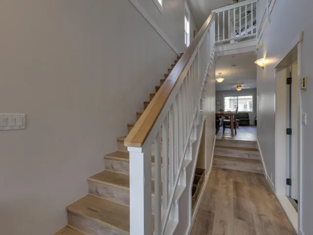 Stairway featuring wood finished floors and ceiling fan