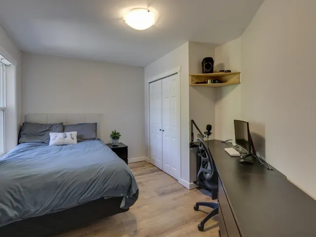 Bedroom with light wood-type flooring, baseboards, and a closet