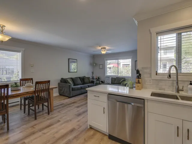 Kitchen featuring dishwasher, crown molding, white cabinetry, and a sink