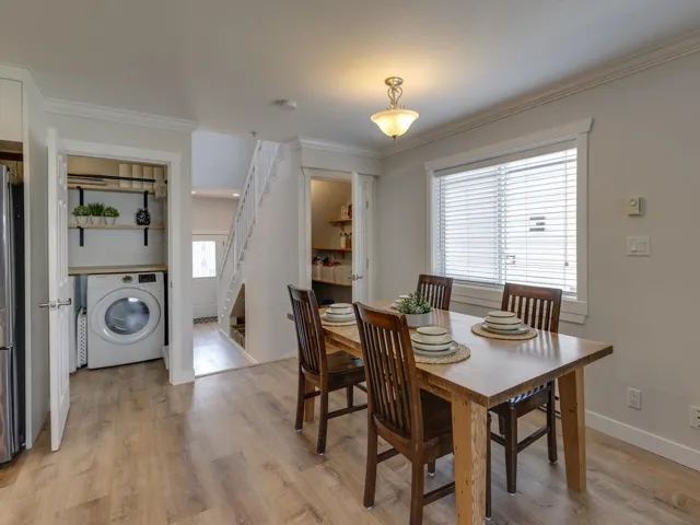 Dining area featuring light wood finished floors, a wealth of natural light, stairs, and washer / clothes dryer