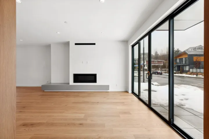Unfurnished living room with light wood-style floors, baseboards, and a glass covered fireplace