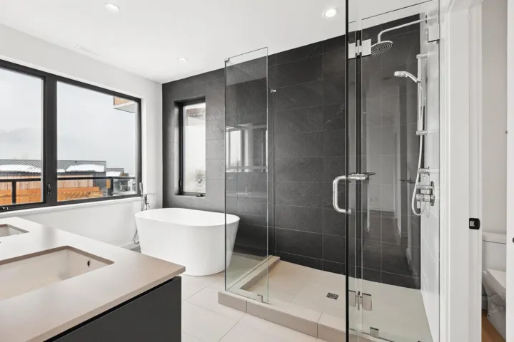 Bathroom featuring toilet, a stall shower, a freestanding bath, and vanity