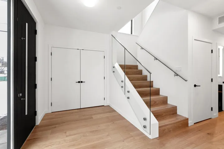 Entryway with light wood-style floors, visible vents, and stairs