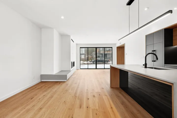 Kitchen with a sink, baseboards, light countertops, light wood-type flooring, and modern cabinets