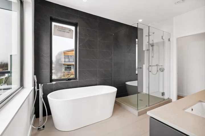 Full bathroom featuring a stall shower, a freestanding bath, tile walls, and vanity
