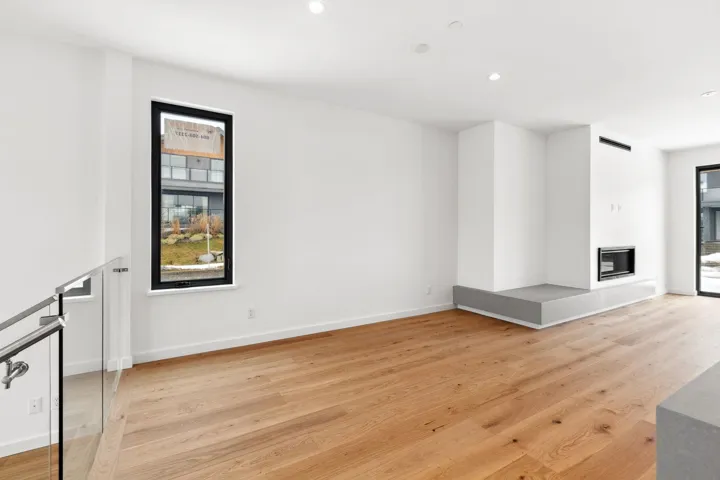 Unfurnished room with light wood finished floors, recessed lighting, baseboards, and a glass covered fireplace