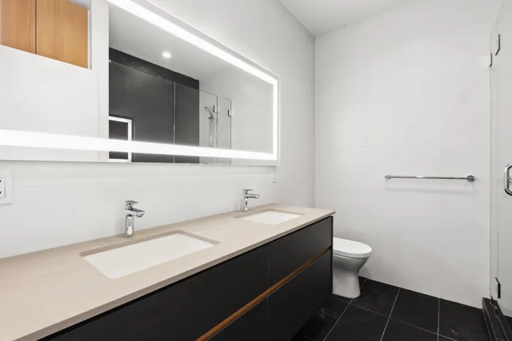 Bathroom featuring a stall shower, a sink, toilet, and tile patterned floors