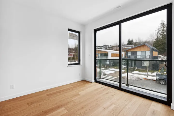 Empty room featuring a wealth of natural light, visible vents, baseboards, and wood finished floors