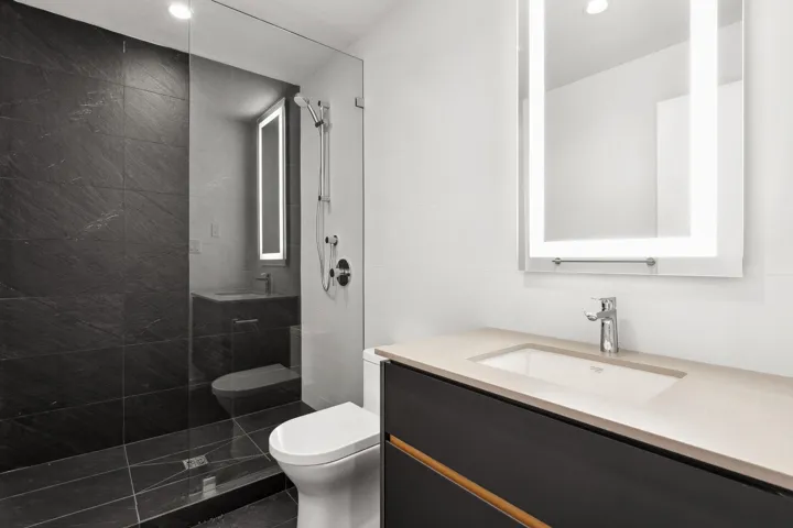 Full bath featuring recessed lighting, a tile shower, vanity, and toilet
