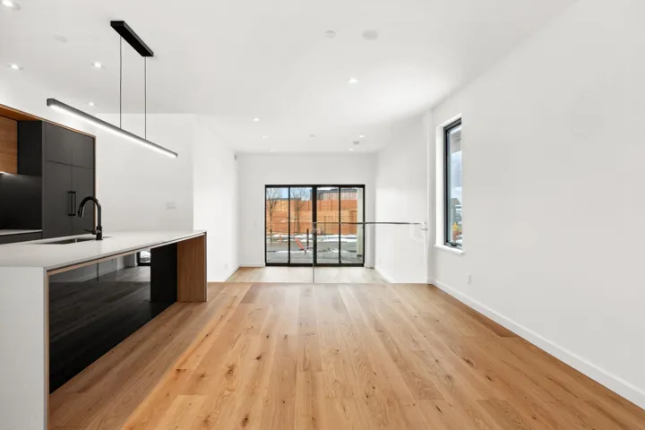 Unfurnished living room featuring light wood finished floors, baseboards, a sink, and recessed lighting