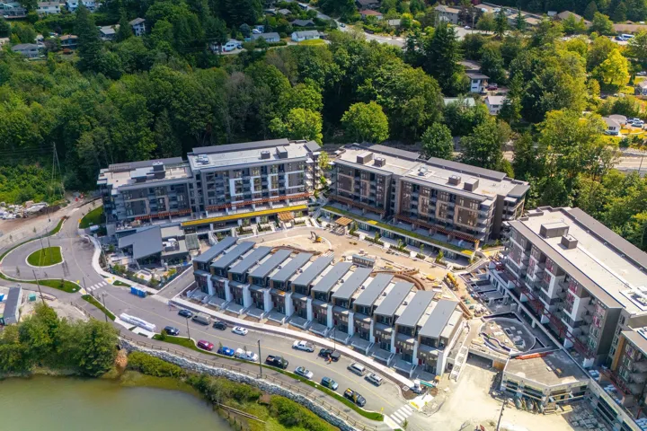 Aerial view of property and surrounding area featuring apartment complex