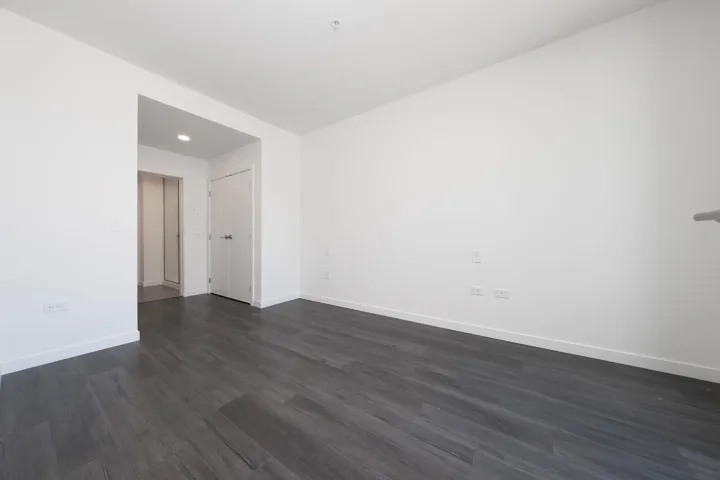 Empty room featuring dark wood finished floors and recessed lighting