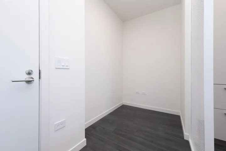 Unfurnished room with dark wood-type flooring and baseboards