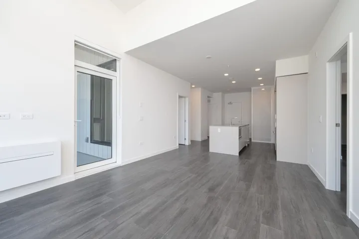 Unfurnished living room featuring dark wood-style flooring and recessed lighting