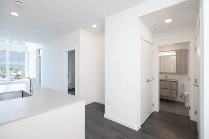 Corridor with dark wood-style floors and recessed lighting