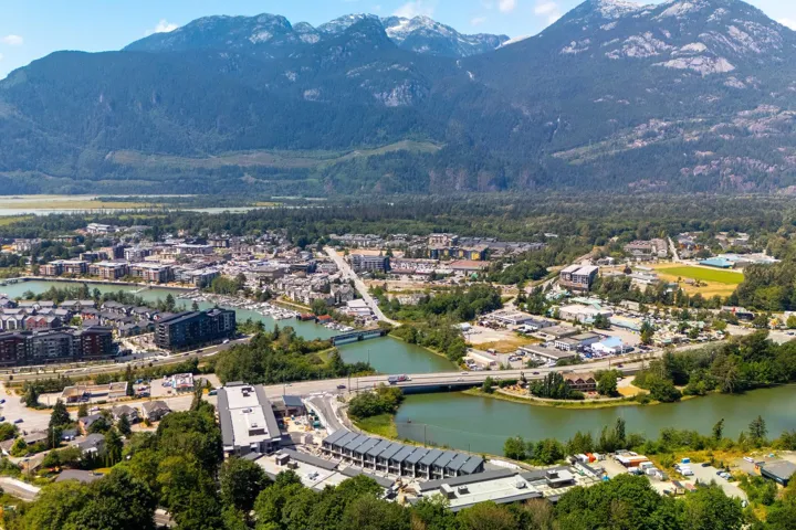 Aerial view of property and surrounding area featuring a water and mountain view and a notable bridge