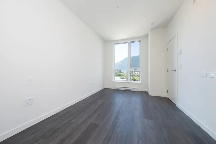 Spare room with dark wood-style flooring and baseboard heating