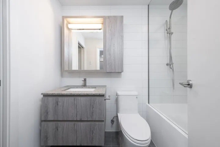 Full bath featuring vanity, shower / washtub combination, and tile walls