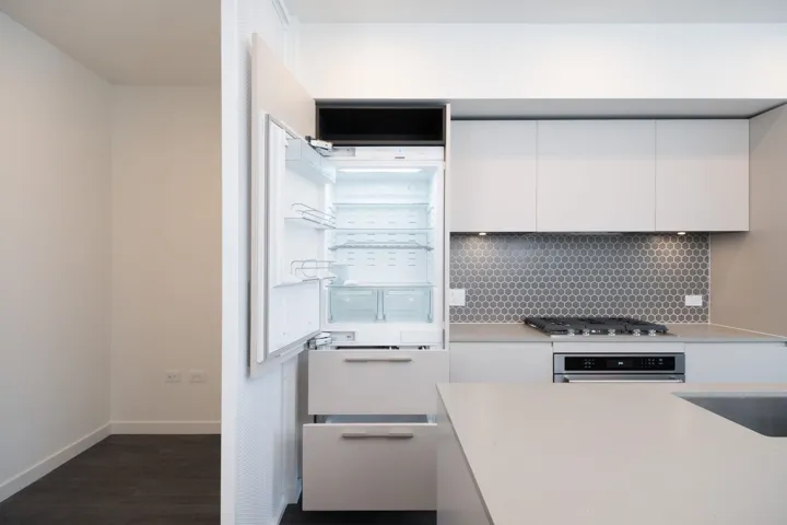 Kitchen with white cabinetry, backsplash, freestanding refrigerator, and dark wood-type flooring