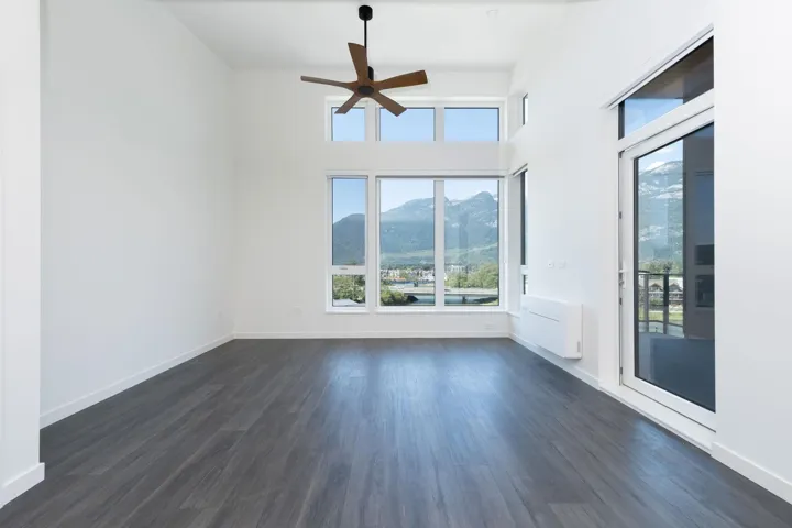 Spare room with a mountain view, ceiling fan, and dark wood-style floors