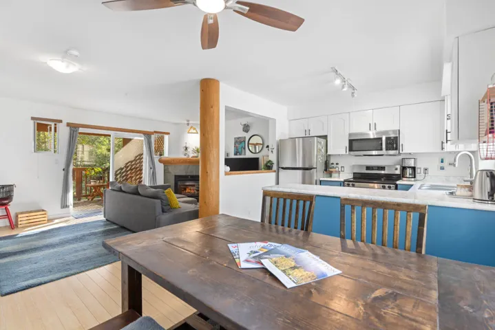Dining area featuring light wood-style flooring, a fireplace, a ceiling fan, and track lighting