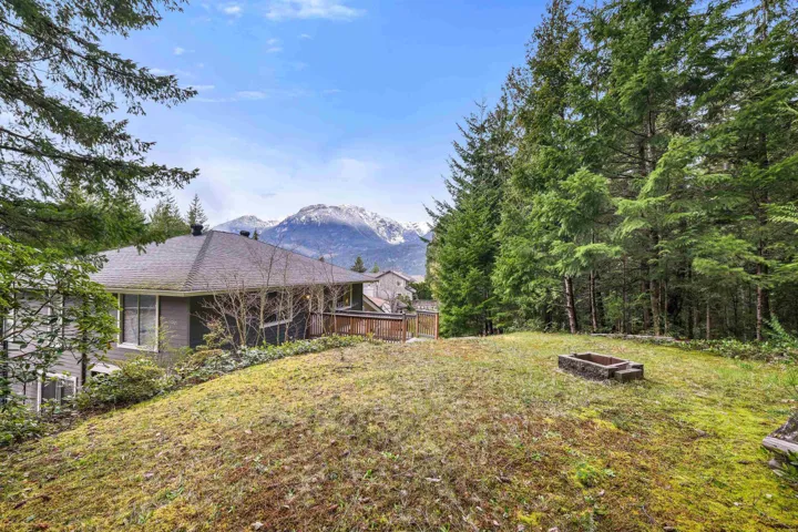 View of grassy yard with a fire pit and a mountain view