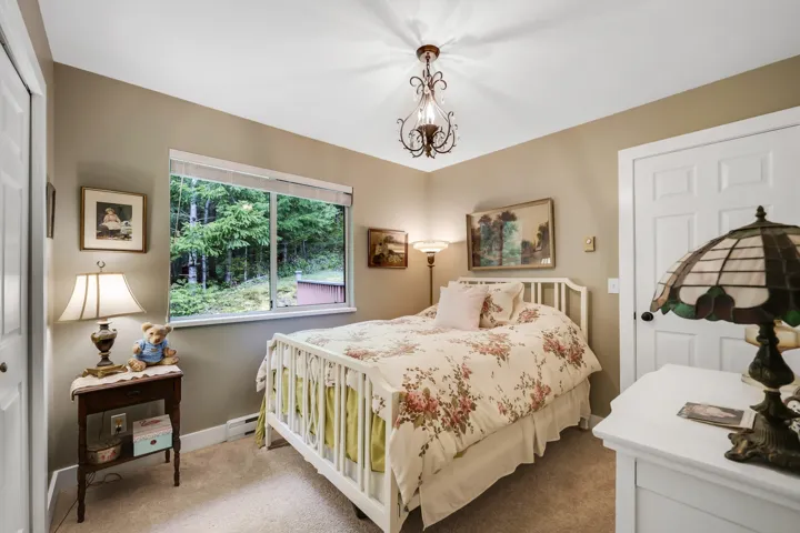 Bedroom featuring carpet flooring, a baseboard radiator, suspended lighting, and a closet