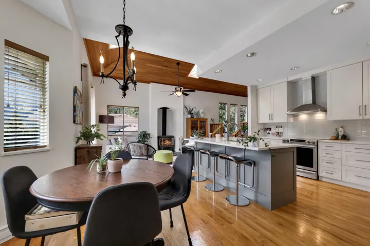 Dining room with a wood stove, light wood finished floors, ceiling fan, and recessed lighting