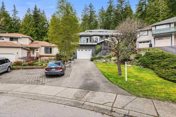 View of front facade featuring a front lawn and asphalt driveway