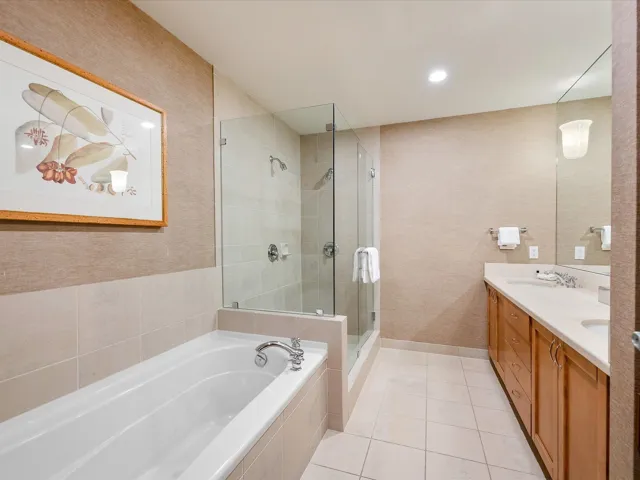 Bedroom featuring light carpet, ensuite bath, visible vents, and baseboards