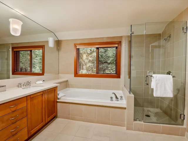 Full bath featuring double vanity, a sink, a shower stall, and a bath