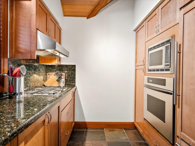 Kitchen with wood ceiling, a sink, lofted ceiling with beams, and backsplash