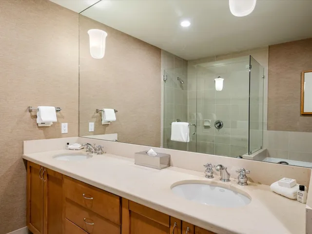 Bathroom featuring a sink, a bath, tile patterned floors, double vanity, and a stall shower